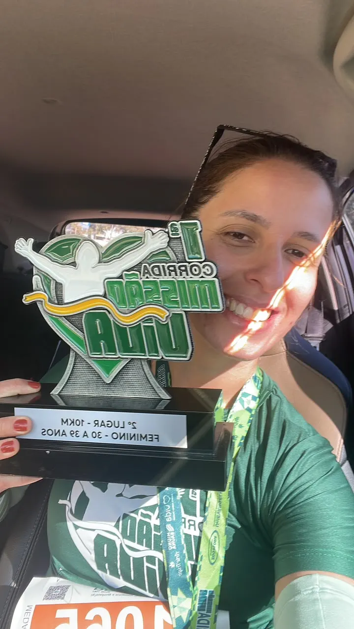 Foto real de aluna com troféu de corrida
